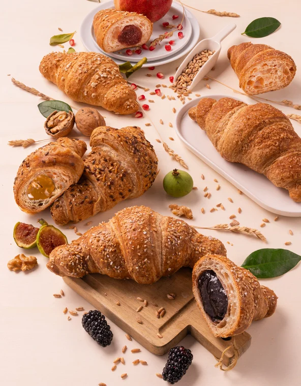 Croissants aux graines fourrés de fruits, entourés de figues, noix, mûres et grenade