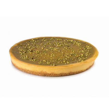 Tarte ronde nappée d'un glaçage caramel lisse, pâte façon biscuit, éclats de pistache sur le dessus.