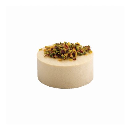 Gâteau rond couleur crème garni de pistaches concassées et de fruits secs, fond blanc.