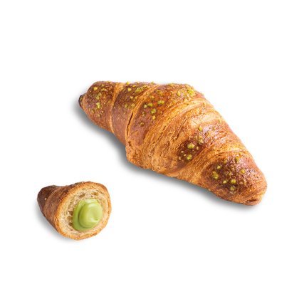 Croissant doré recouvert d'éclats de pistache, avec un petit morceau coupé révélant la crème de pistache verte.