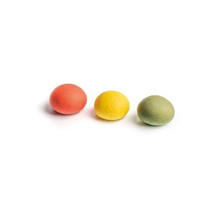 Trois bonbons ronds et texturés, rouge, jaune et vert, alignés sur fond blanc.