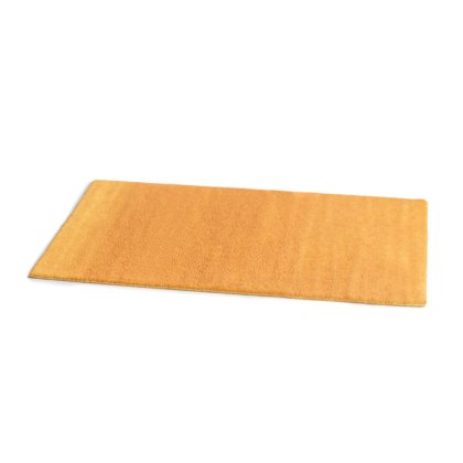 Tapis rectangulaire jaune moutarde à poils épais, présenté en angle sur fond blanc.
