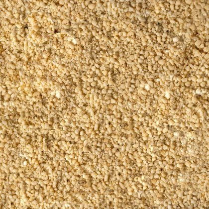 Gros plan sur une poudre jaune pâle fine et granuleuse, à la texture grossière et friable, couvrant tout le cadre.
