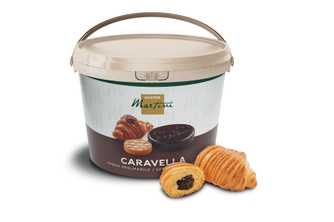 Grand seau de crème à tartiner au chocolat Master Martini Caravella à côté de deux croissants fourrés au chocolat.