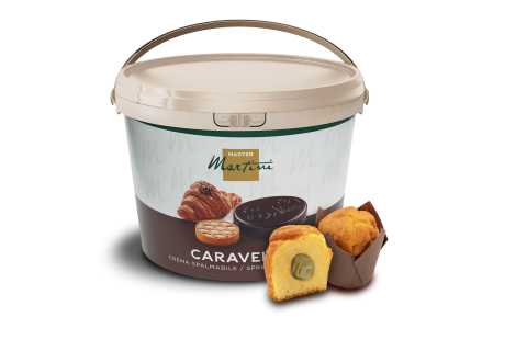 Grand seau de crème à tartiner Master Martini Caravel à côté d'un muffin coupé fourré et d'un muffin entier.