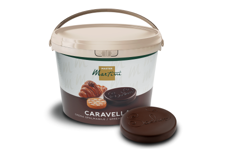 Grand seau blanc de crème à tartiner Master Martini Caravella à côté d'un disque de chocolat noir gravé