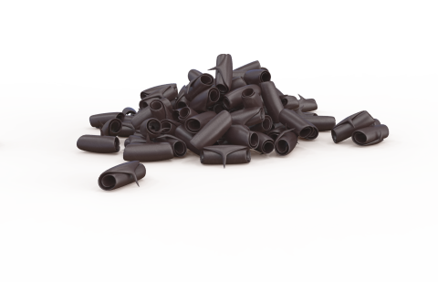 Petits capuchons en plastique noir en forme de tube éparpillés sur fond blanc