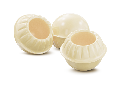 Trois coques rondes en chocolat blanc aux bords festonnés, deux évidées, sur fond blanc.