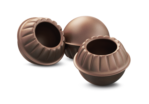 Trois coques de chocolat rondes et vides, aux bords festonnés et au centre creux, sur fond blanc.