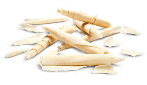 Copeaux enroulés de chocolat blanc et pièces en forme de volute sur fond blanc