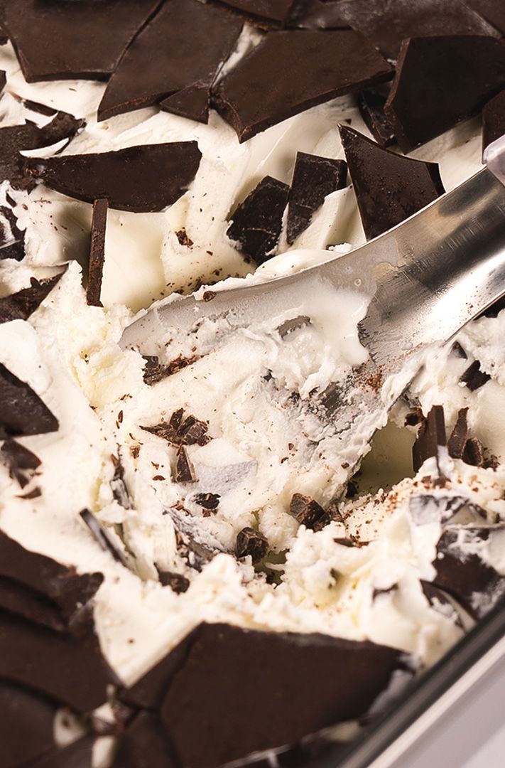 cuillère en métal plongée dans une glace stracciatella garnie d'éclats de chocolat noir